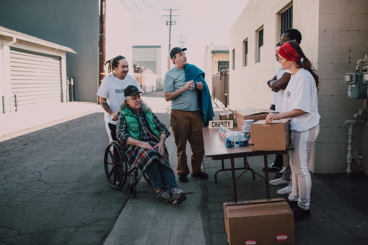 A diverse group of volunteers organizing a charity event outdoors, engaging with the local community.