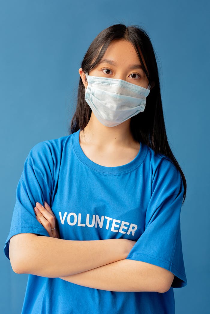 Portrait of a young volunteer with a face mask, symbolizing community service and health safety.